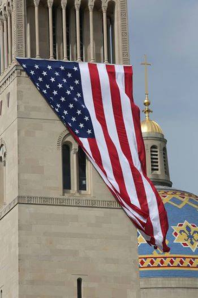 Large flag hangs from the bell tower of the Basilica of the National Shrine of the Immaculate Conception in Wash DC today.  (photo cred: Catholic News Service)